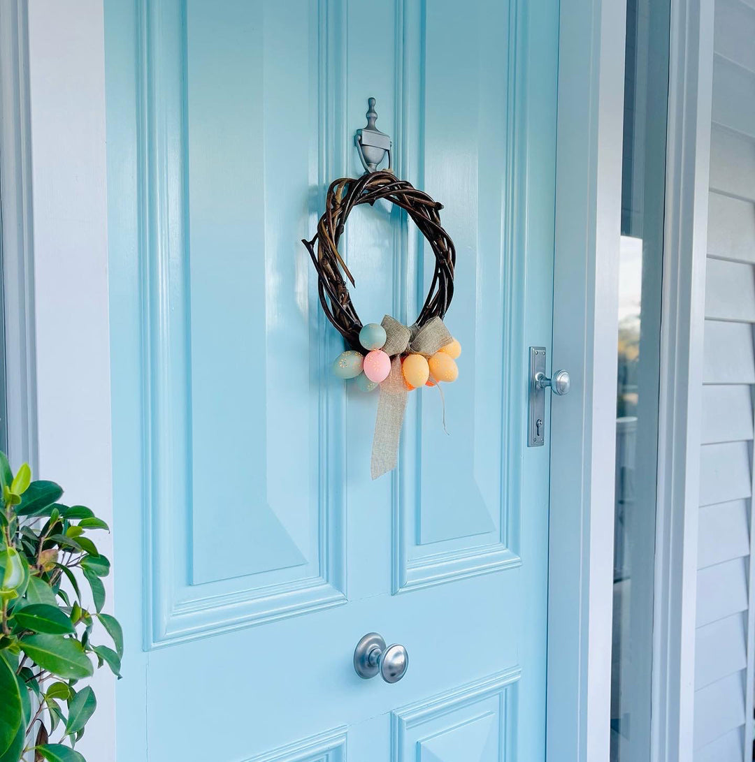 Front door decorated with Easter themed wooden wreath.